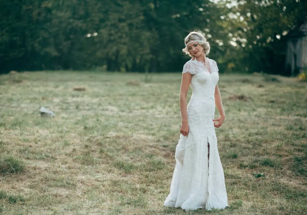 Braut auf einer Wiese im Meerjungfrauenkleid mit Beinschlitz